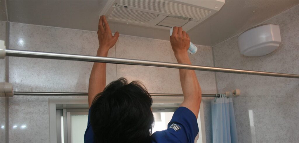 浴室の換気扇を清掃する作業