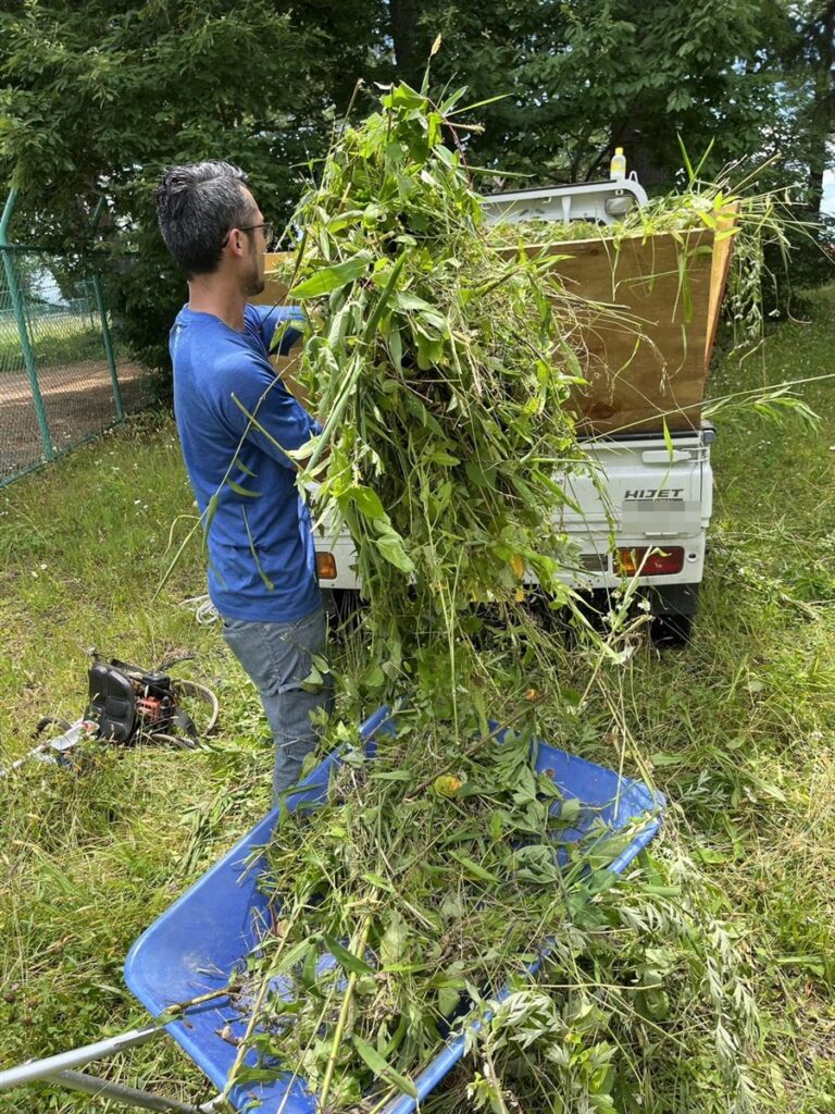 刈った草を軽トラックに積み込む作業